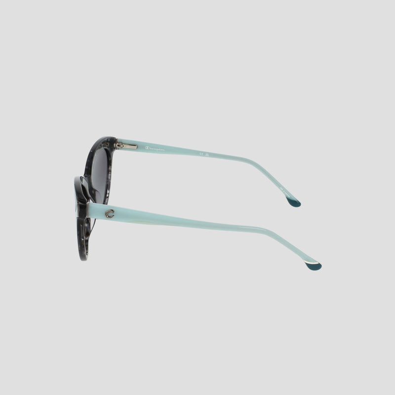 Side view of the Champion Women's Polarized Cateye sunglasses, featuring black and white tortoiseshell frames, light blue arms, and gradient lenses, set against a plain light grey background.