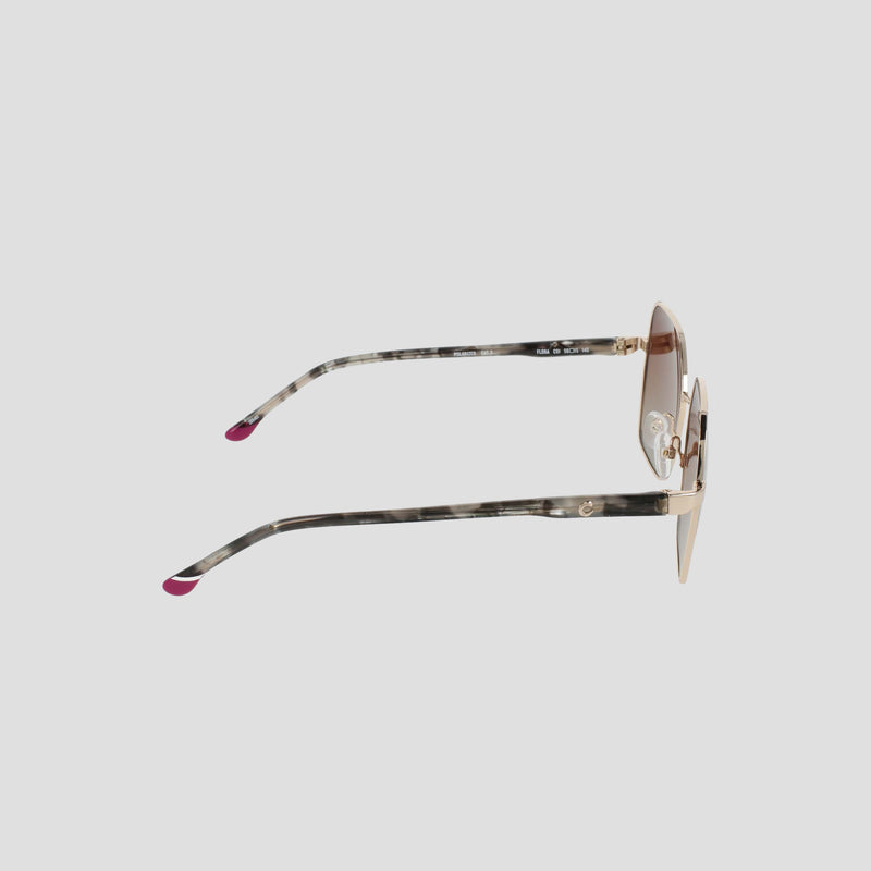 Side view of the Champion Women's Polarized Boho Square sunglasses, showcasing a stylish square silhouette with thin gold metal frames and patterned temples tipped in pink. The light brown lenses feature a subtle gradient tint, all set against a plain light gray background.