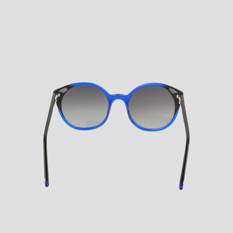 The Women's Polarized Flirty Round sunglasses by Champion feature a bright blue handmade acetate frame and dark gradient lenses, displayed against a plain light gray background.