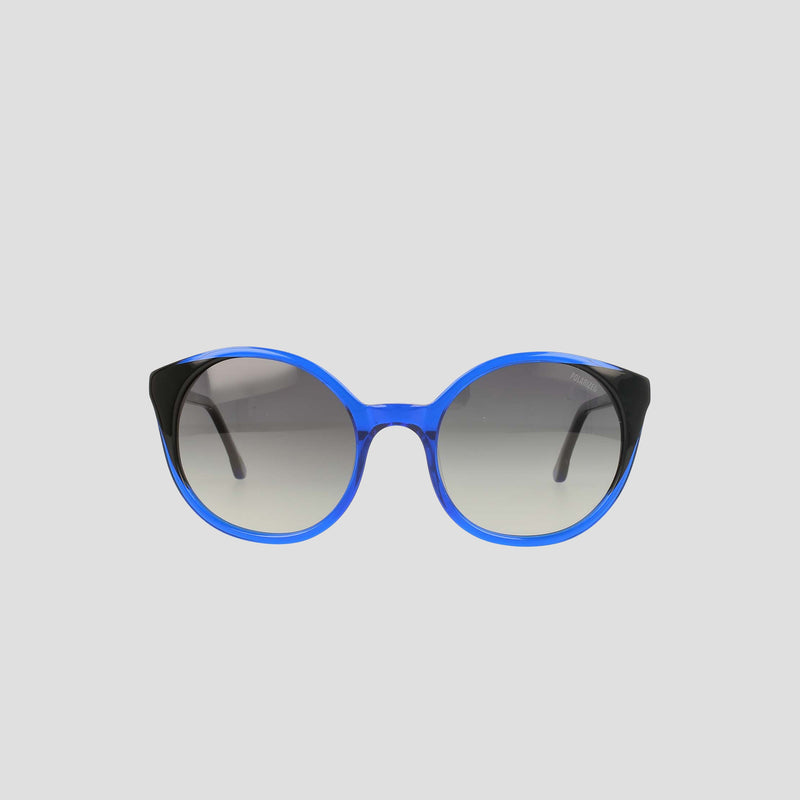 Champion's Women's Polarized Flirty Round sunglasses, featuring blue rims, black temples, and gradient lenses in handmade acetate for a refined finish, are displayed against a plain light gray background.