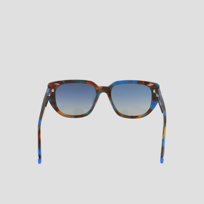 Front view of the Champion Women's Polarized Modified Cateye sunglasses featuring a handmade multicolored tortoiseshell acetate frame and blue gradient lenses, set against a plain light gray background.