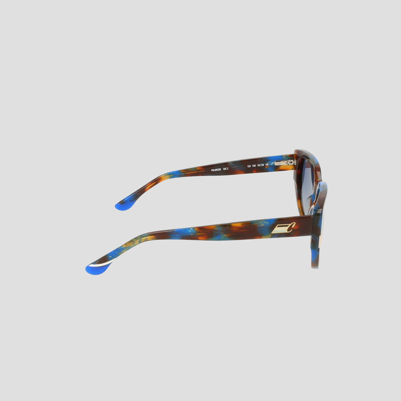 Side view of the Champion Women's Polarized Modified Cateye sunglasses, showcasing blue and brown marbled handmade acetate frames with gold accents and polarized lenses, set against a light grey background.