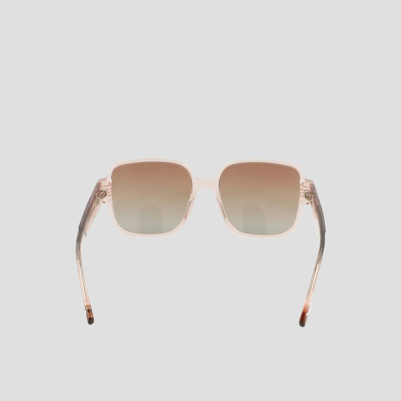 The Champion Women's Polarized Glam Square sunglasses feature light brown gradient polarized lenses and transparent beige handmade acetate frames, shown on a plain light gray background with arms slightly angled outward.