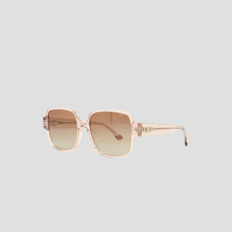 The Champion Women's Polarized Glam Square sunglasses feature oversized square frames in translucent light pink handmade acetate with brown-tinted polarized lenses, shown on a plain light gray background.