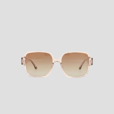 The Champion Women's Polarized Glam Square sunglasses feature oversized square frames in light pink transparent handmade acetate with brown gradient lenses, shown on a plain light gray background.