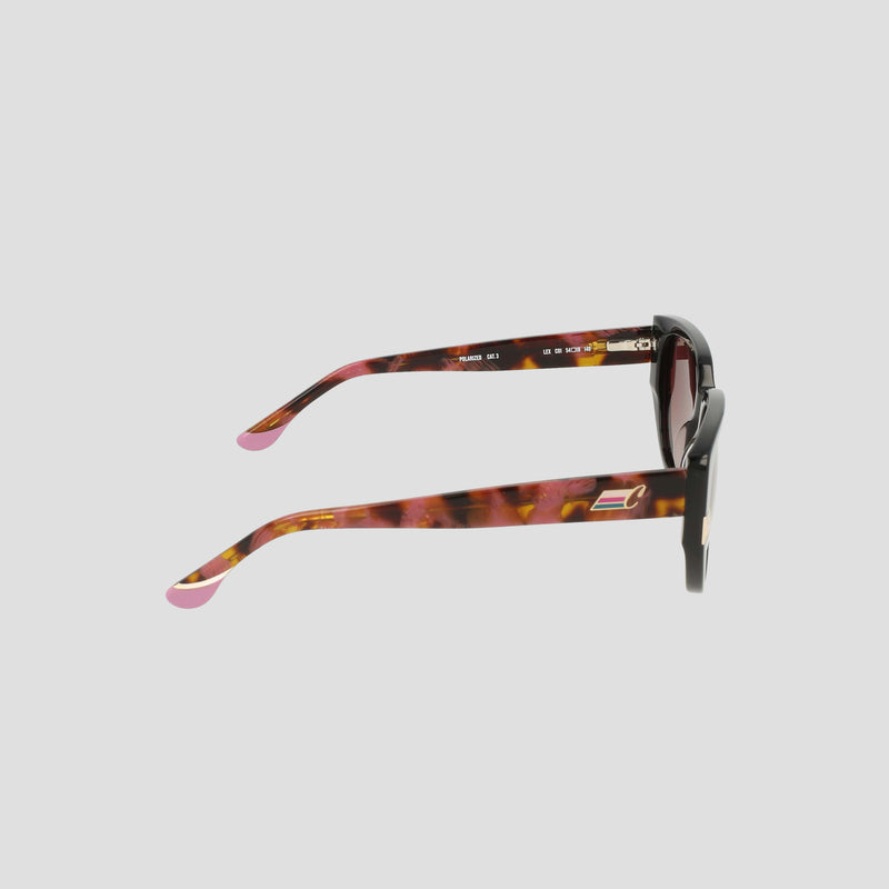 Side view of Champion Women's Polarized Modified Cateye sunglasses in luxury tortoiseshell, showcasing thick arms with pink tips and gold rectangular accents near the hinges, crafted from handmade acetate and set against a plain light gray background.