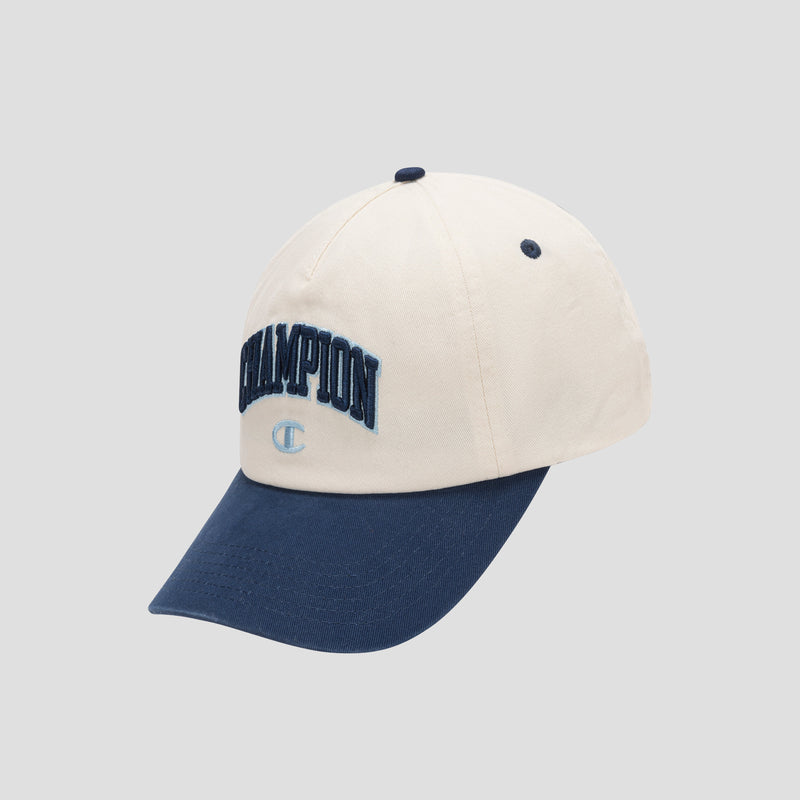 The Amor Adjustable Baseball Cap by Champion is a premium two-tone cap made from cotton twill, showcasing a cream-colored crown, navy blue brim, and bold blue CHAMPION embroidery on the front for unmistakable brand authenticity.