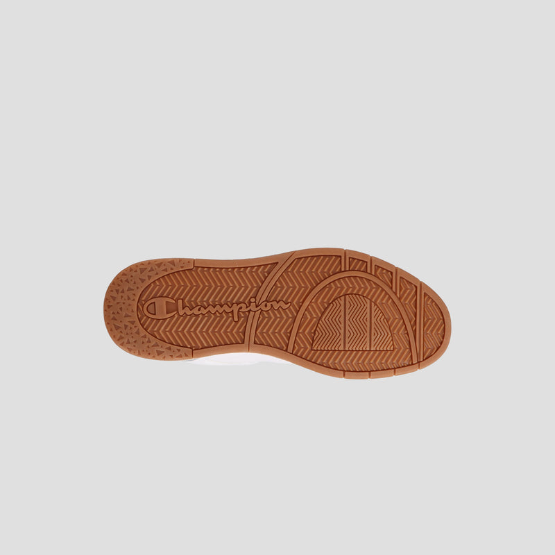 The image displays the bottom of the Champion Men's Arena Lo V2 sneaker, showcasing a brown rubber sole with textured patterns and "Champion" embossed at the center, set against a light gray background that emphasizes its heritage style.
