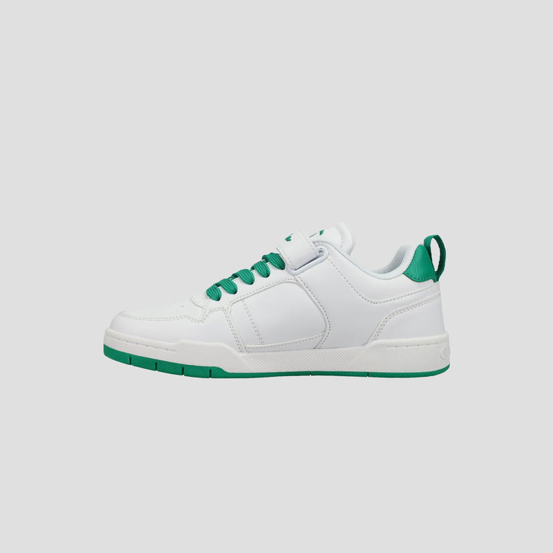 The Champion Kids' Arena Power Low sneaker features a white design with green laces, heel tab, and sole, channeling classic Champion style against a plain light gray background.