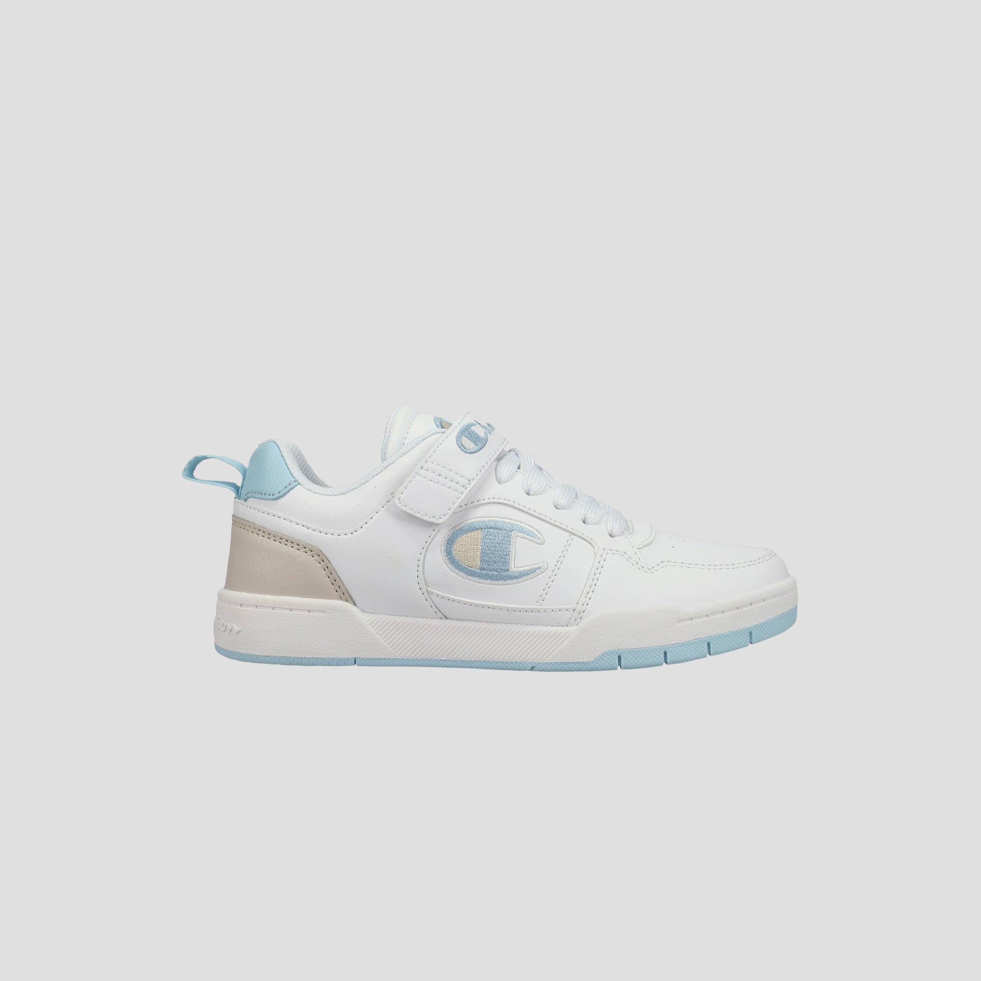 The Champion Kids' Arena Power Low sneaker is white with light blue accents on the sole, heel, and laces. It features a large C logo, a convenient back pull tab, and classic Champion style in a low-top design.