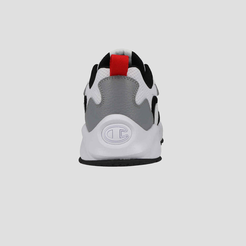 A rear view of the Champion Men's 9318 Vale sneaker shows a white rubber sole, gray heel, white and black upper, red pull tab, and embossed logo. The cushioned collar adds comfort. Background is plain light gray.