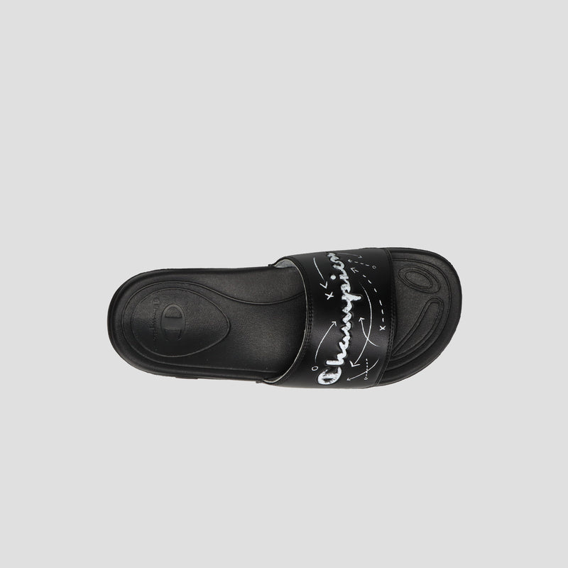 The Champion Kids' Mega SFB Slide is a black sandal with a wide strap featuring white handwritten-style text and graphic accents. It has a contoured, textured footbed and offers lightweight comfort, shown from above on a gray background.