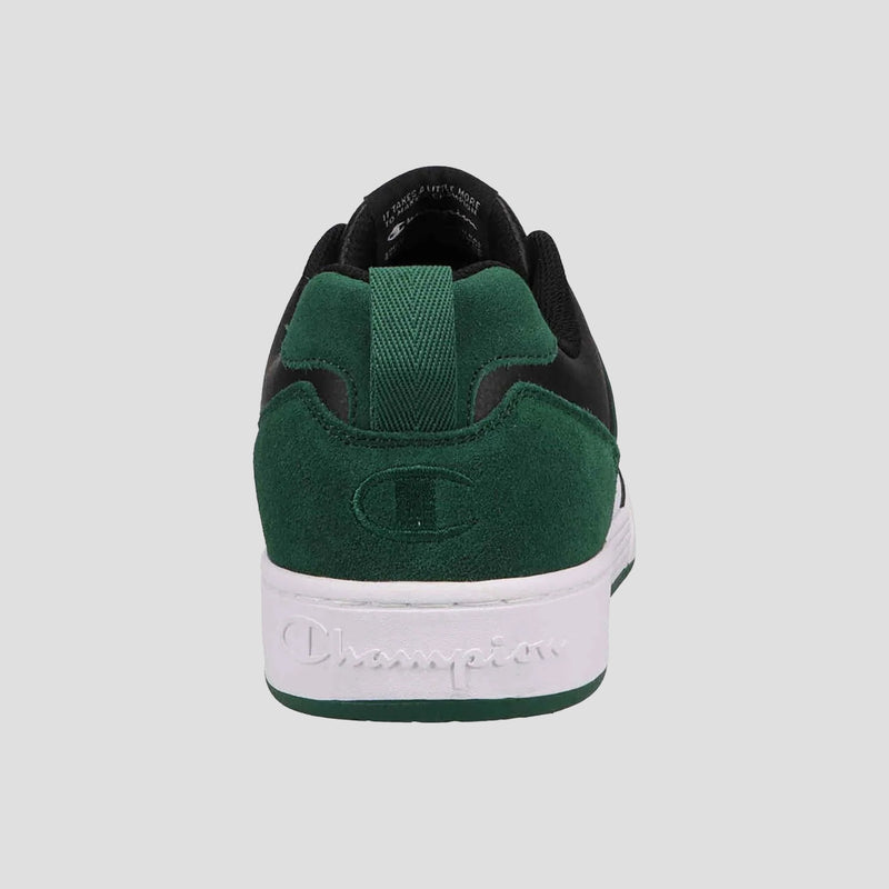 The Champion Men's 5-on-5 Low sneaker in green and black is shown from the back, featuring a cushioned collar, suede heel embossed with a logo, and a white sole with "Champion" written on it.