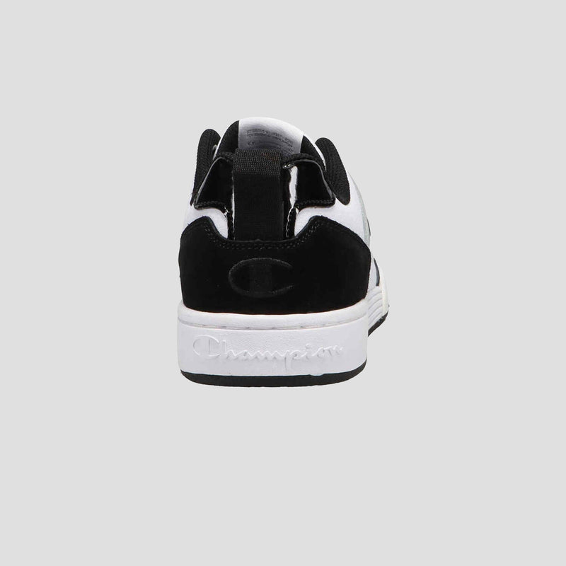 The Champion Women's 5-on-5 Low sneaker is shown from the back in white and black with a cushioned collar, black heel, and "Champion" embossed on the white sole. A solid light gray background highlights its minimalist design.
