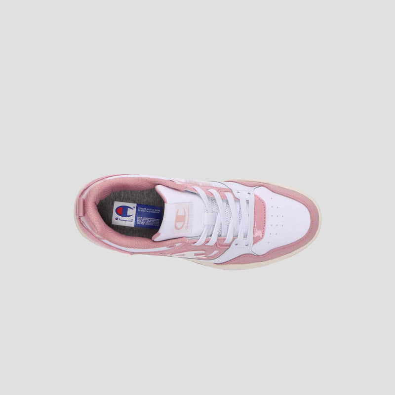 Top view of the Champion Women's 5-on-5 Low sneaker in white and light pink, featuring a cushioned collar, white laces, and a blue tongue tag, set on a plain light gray background.