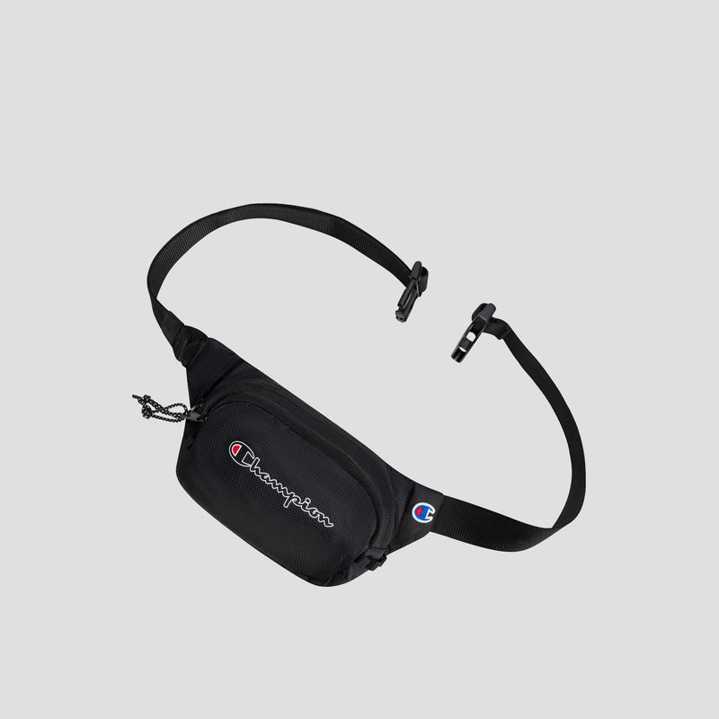 A sleek black Champion Center Waist Pack with an adjustable strap and buckle, featuring the embroidered Champion logo in white, red, and blue on the front pocket. The background is plain light gray.