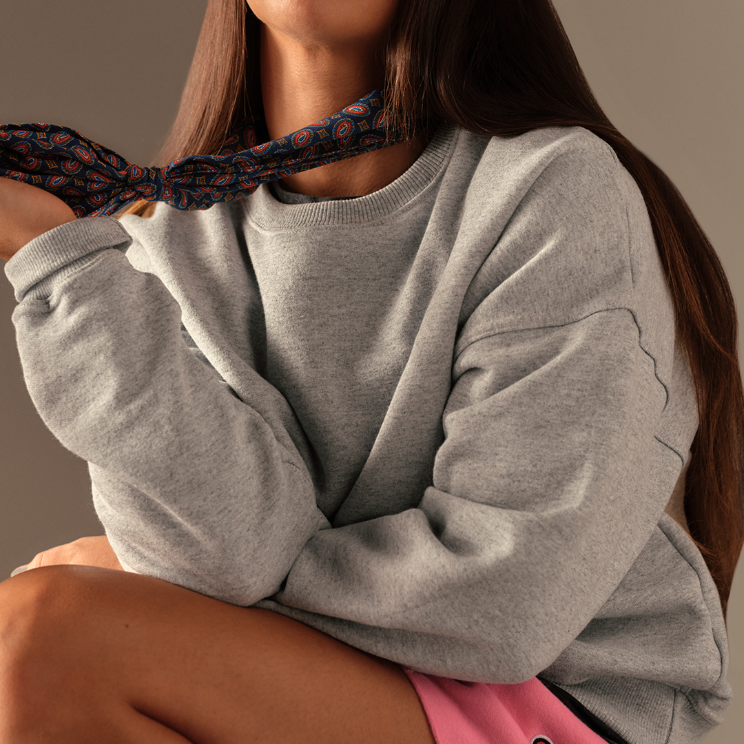 Person wearing a gray sweatshirt with a blurred background