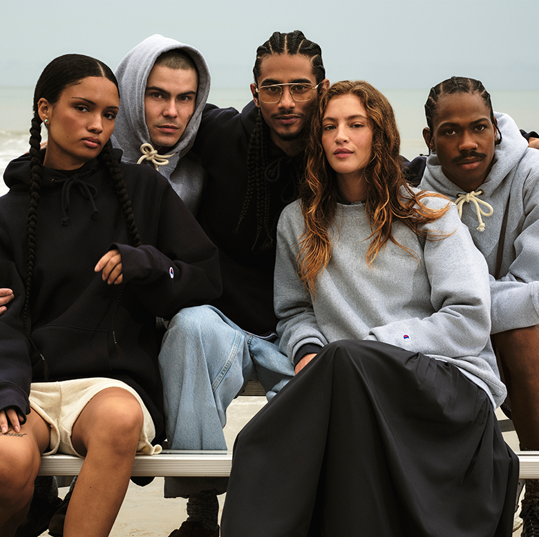 Group of people sitting together on a bench with a neutral background