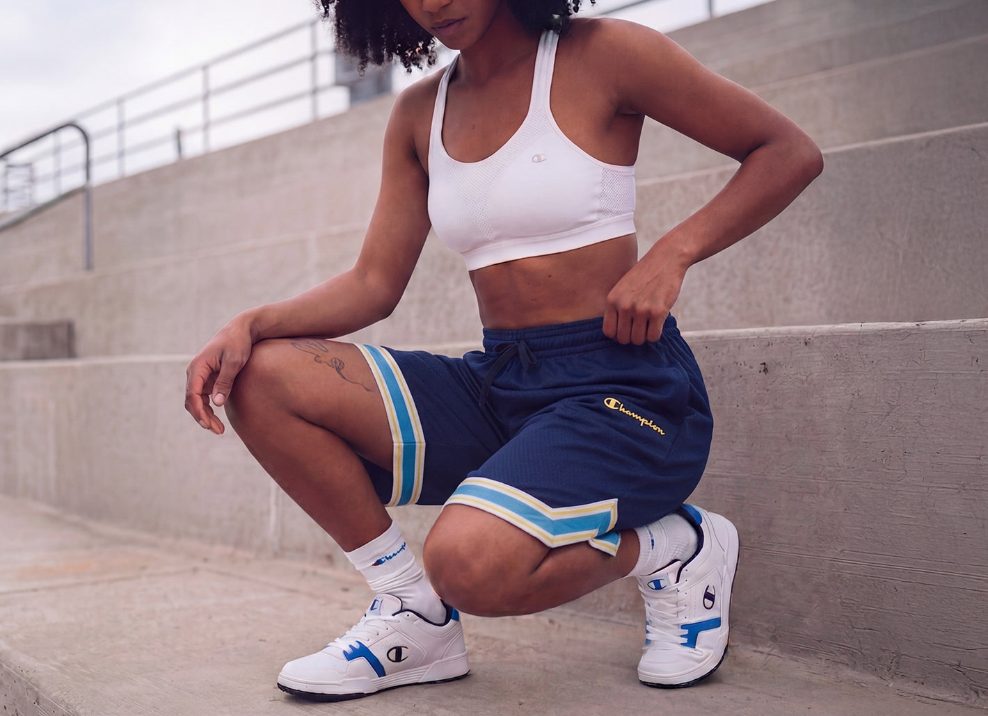Person wearing Champion sports outfit sitting on concrete steps