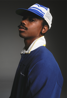 Man wearing a blue cap and jacket against a dark background