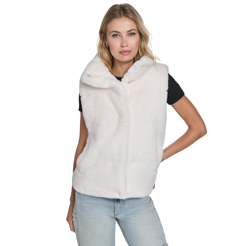 A woman models the Champion Puffer Vest, layering it over a black t-shirt and light blue ripped jeans for a stylish cold-weather look against a plain white background.