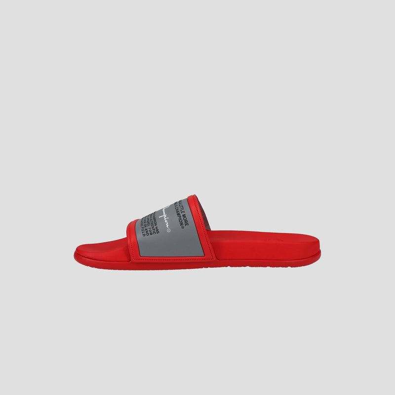 A red Champion Men's IPO Squish Slide with a gray strap and black and white text, featuring a lightweight flat sole, contoured footbed, and modern design, shown on a plain light gray background.
