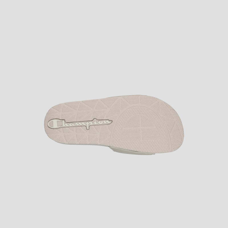 The image displays the sole of the Champion Women's IPO Slide, featuring a textured pattern for grip and the embossed Champion logo, all designed for lightweight comfort.