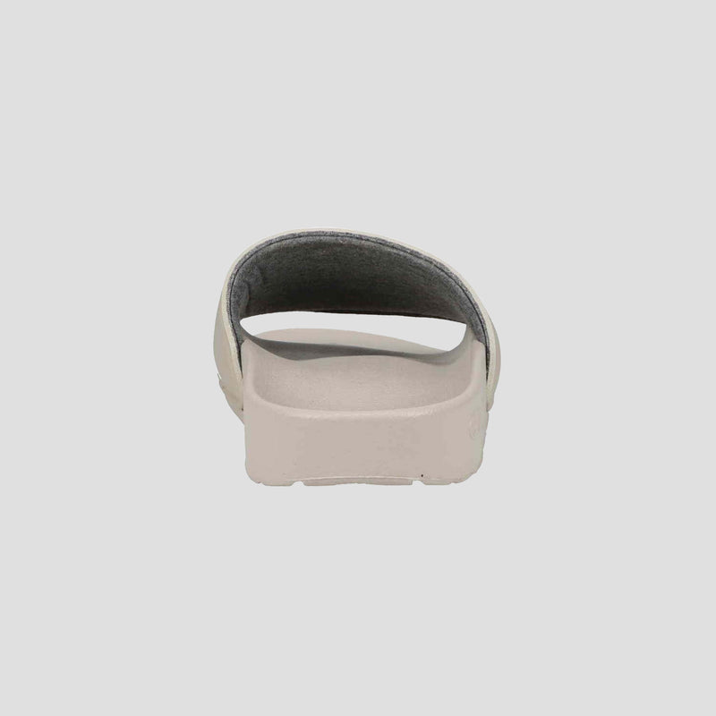A Champion Women's IPO Slide in beige, shown from the back with an open heel and contoured footbed, offers lightweight comfort against a plain, light background.
