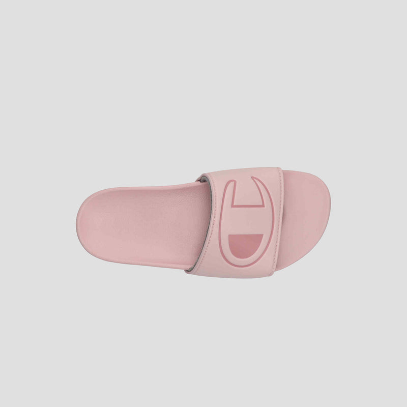 The Champion Women's IPO Slide is a pink slide sandal with a wide strap and large embossed logo. Viewed from above on a light background, its contoured footbed ensures extra comfort for supportive, stylish wear.