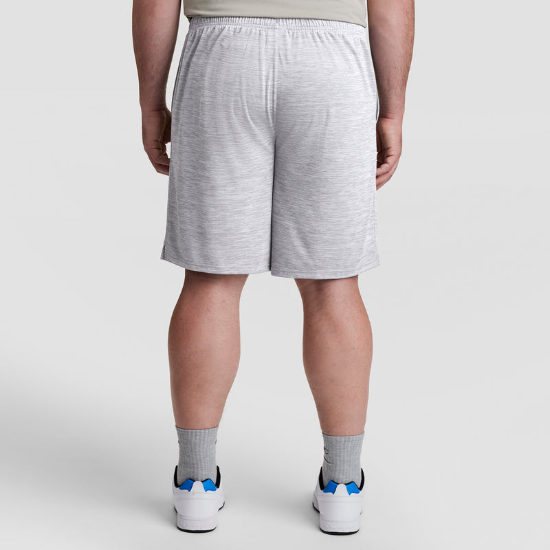 A person wearing Champion 10" Moisture Wicking, Sport Shorts - Big & Tall in light gray, paired with gray socks and white sneakers with blue accents, shown from the back against a plain light gray background.