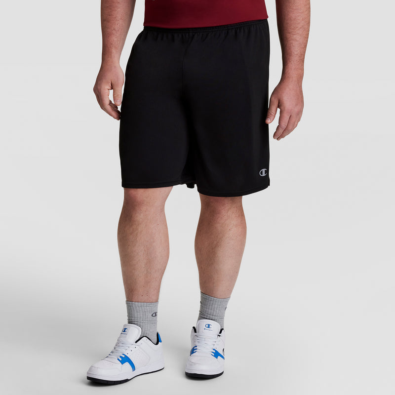 A person wearing a maroon shirt, black Champion 10" Moisture Wicking, Sport Shorts - Big & Tall, gray Champion DOUBLE DRY socks, and white sneakers stands against a plain light gray background; only the body from shoulders down is shown.