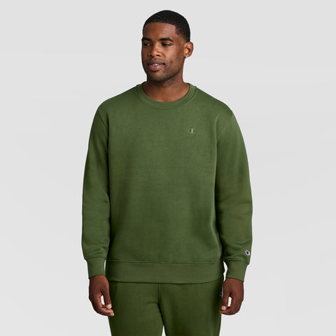 A man wearing an olive green Powerblend Crewneck Sweatshirt, C Logo - Big & Tall with a small logo on the chest and matching sweatpants.