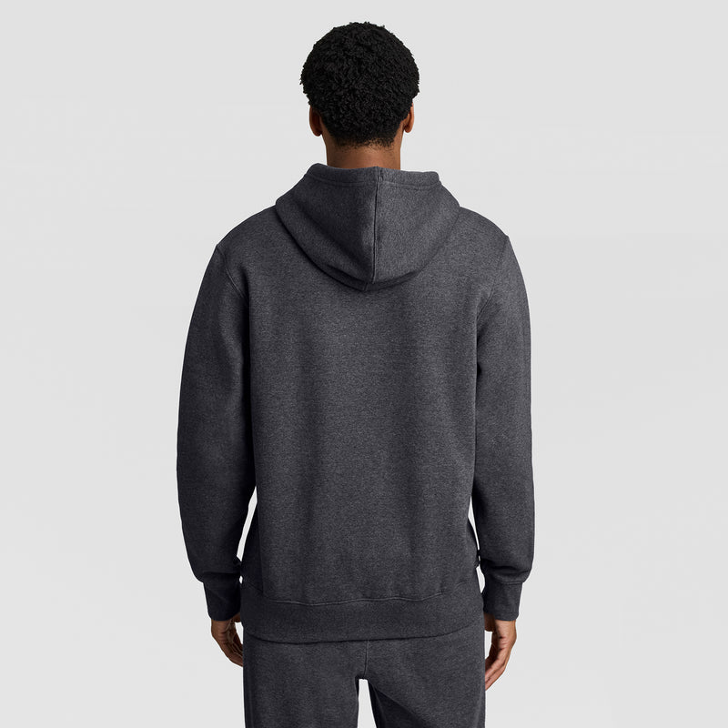 A person wearing the Champion Powerblend Hoodie, Full Script Logo in dark gray with matching pants is shown from the back, standing against a plain light gray background.