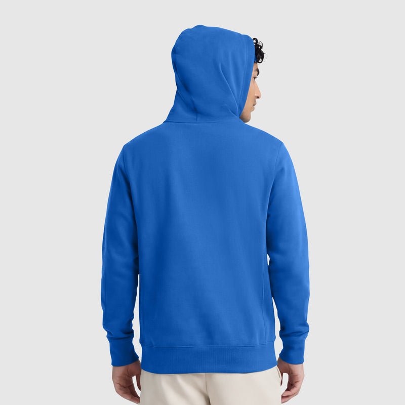 A person faces away from the camera wearing a Champion Powerblend Hoodie, Full Script Logo, in bright blue with the hood up. The classic pullover is shown from the back against a plain light gray background.