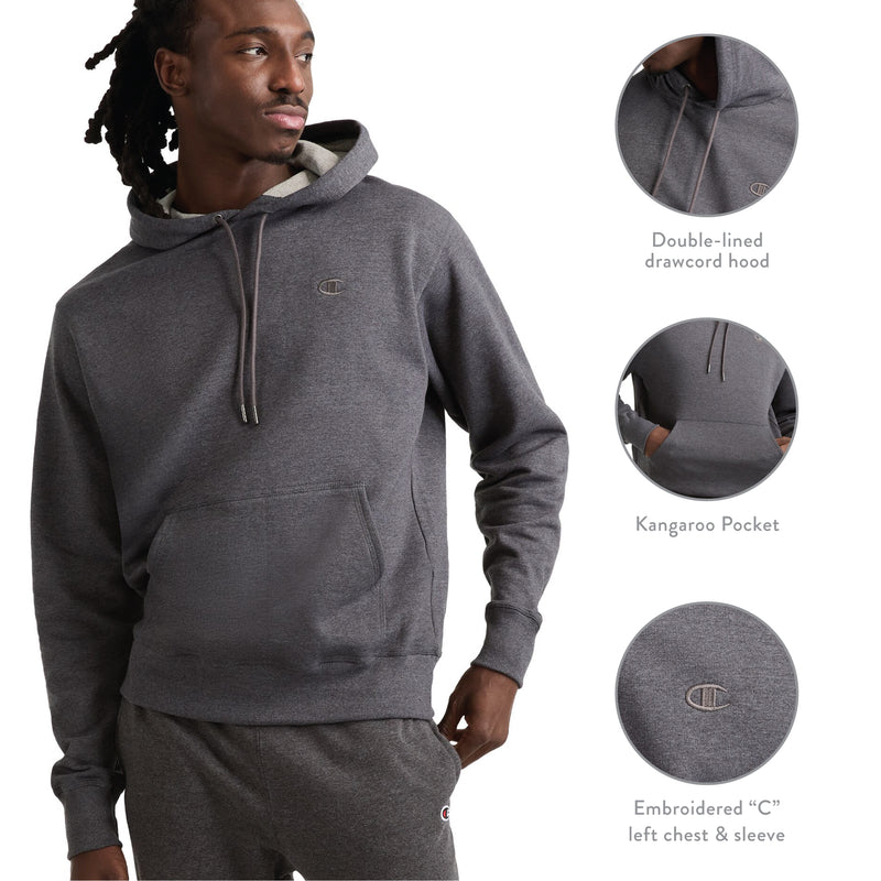 A man wearing the Champion Powerblend Hoodie, C Logo—a dark gray fleece hoodie featuring a kangaroo pocket, double-lined drawcord hood, and embroidered C logos on the left chest and sleeve. Insets highlight each feature of this men’s hoodie.