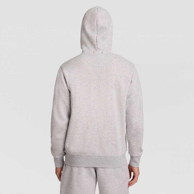 A person is shown from the back, wearing a Champion Powerblend Full-Zip Hoodie with C Logo in light gray, along with matching sweatpants, standing against a plain white background.