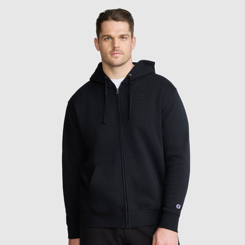 A man wearing a black Champion Powerblend Full-Zip Hoodie, C Logo - Big & Tall with a hood and pockets stands against a light gray background, looking at the camera with a neutral expression.