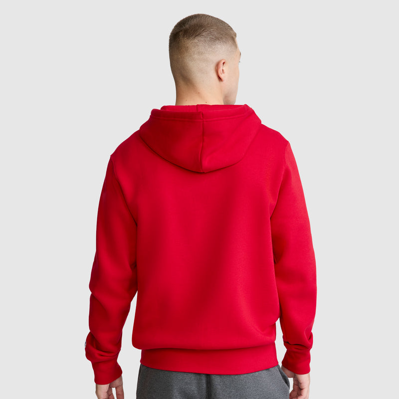 A person with short hair, seen from behind, is wearing a bright red Champion Powerblend Full-Zip Hoodie, C Logo, and gray cinched bottom sweatpants, standing against a plain light gray background.