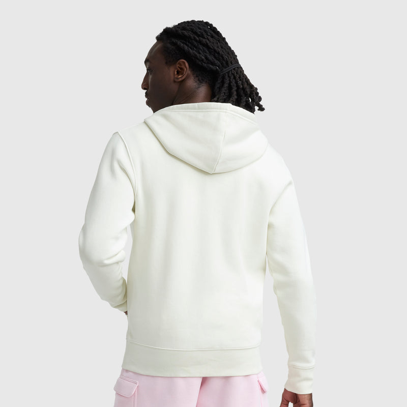 A person with long, braided hair is shown from the back, wearing a white Champion Powerblend Full-Zip Hoodie, C Logo, and light pink pants against a plain light gray background.