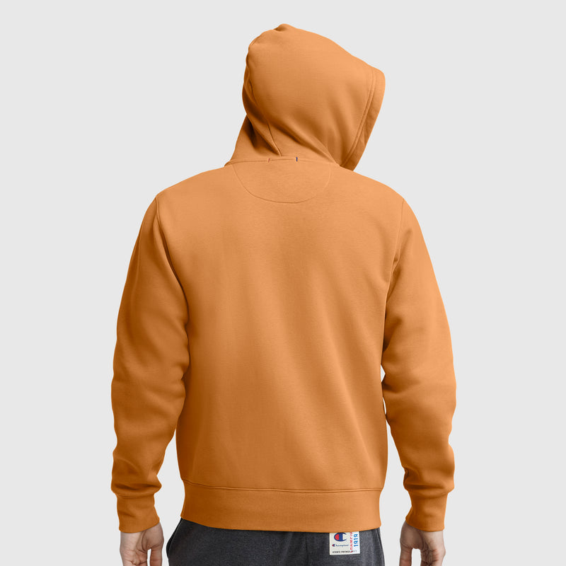 A person wearing a Champion Powerblend Full-Zip Hoodie, C Logo, in orange and gray pants stands facing away, displaying the back and hood of the sweatshirt against a plain light gray background.