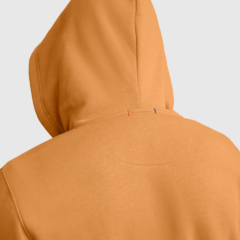 Back view of a person wearing the Champion Powerblend Full-Zip Hoodie, C Logo in tan, highlighting the hood and upper back stitching details, set against a plain light gray background.