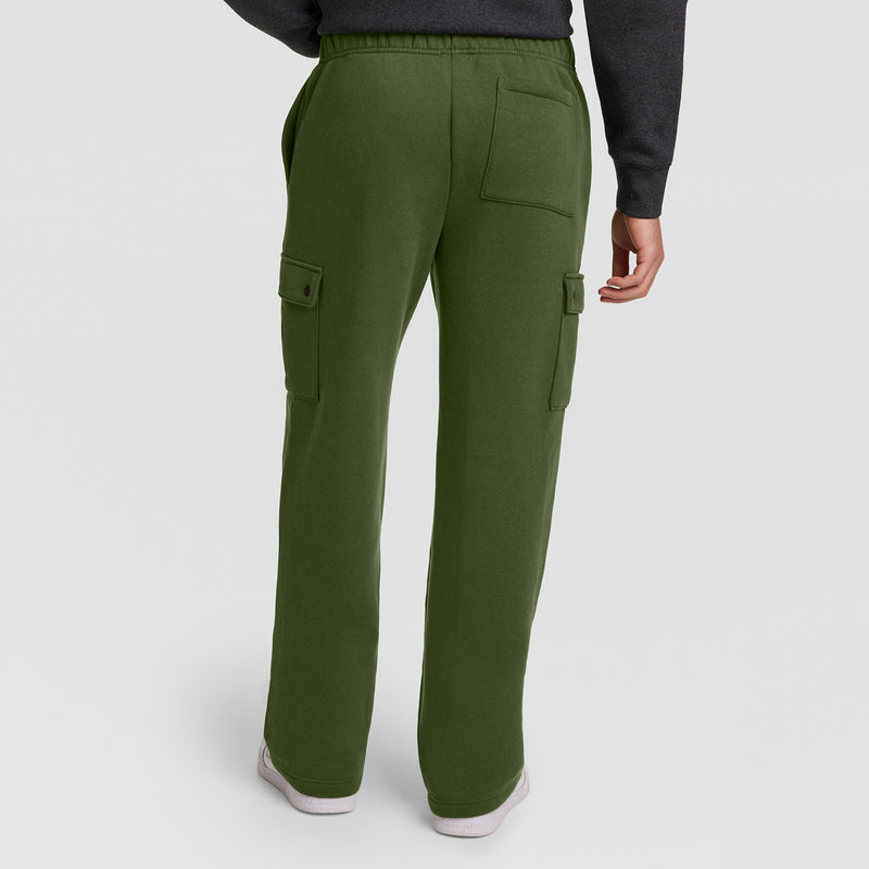 A person is shown from the back wearing the Champion Fleece Cargo Pant, C Logo in olive green, featuring side and back pockets, paired with white sneakers and a dark long-sleeve top, standing against a plain light background.