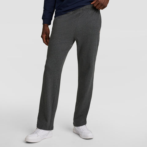 A person wears Champion Lightweight Lounge Pants with open hem and C logo in dark gray, paired with a navy long-sleeve shirt and white sneakers, standing against a plain light background. The image is cropped from the chest down.