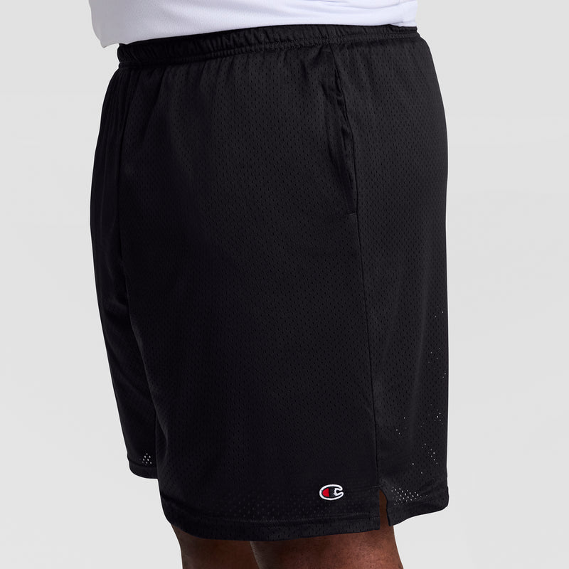 A person models Champion 9" Classic Mesh Shorts, C Logo – Big & Tall in black, showing only the lower torso and upper legs against a plain background. The small Champion logo is visible near the hem.
