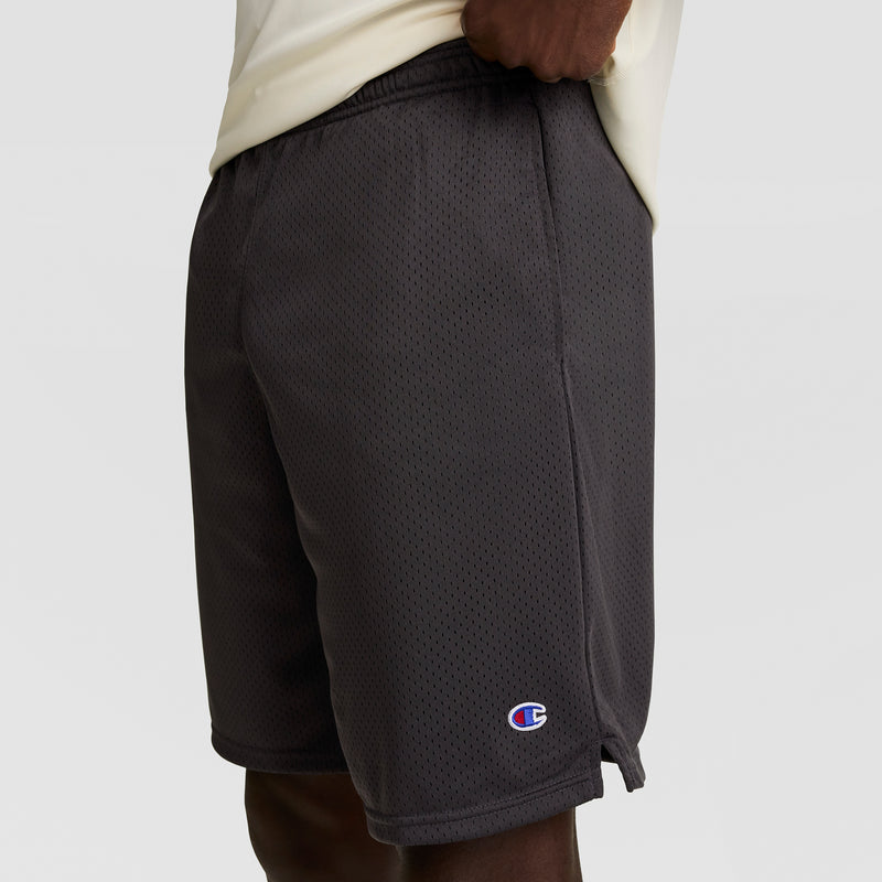A person is shown from the waist down wearing Champion 9" Classic Mesh Shorts, C Logo in dark gray, standing against a plain light background.