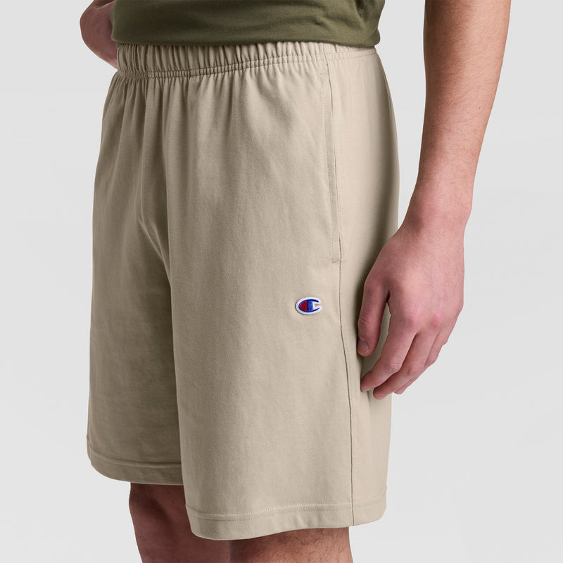 A person wearing Champion 9" Lightweight Lounge Shorts with a C Patch Logo and an elastic waistband stands against a plain white background.