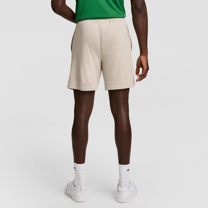 A person in a green shirt, Champion 7" Moisture Wicking Sport Shorts, white crew socks, and white sneakers stands with their back to the camera against a plain white background. The shorts offer DOUBLE DRY technology for all-day comfort.