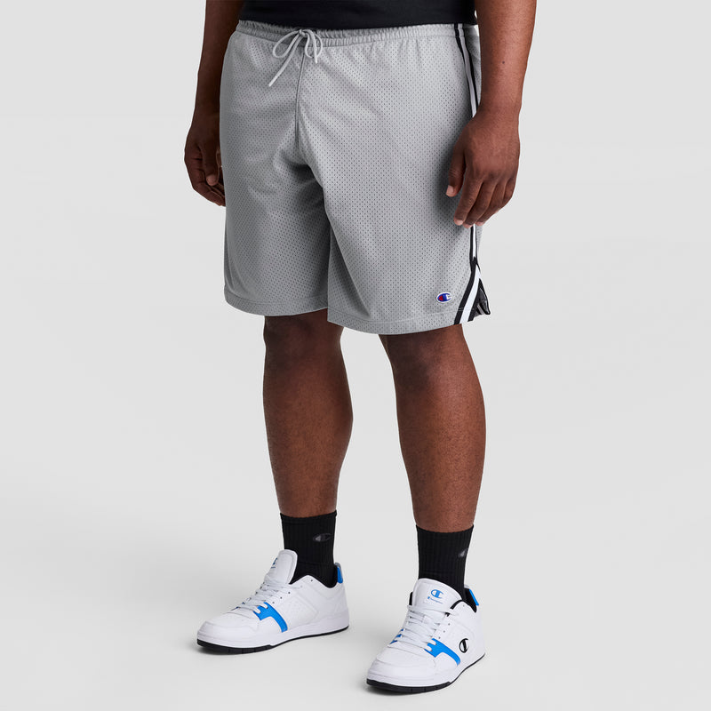Man wearing Champion 10" Lacrosse Mesh Shorts - Big & Tall in grey, paired with black socks and white sneakers with blue accents.