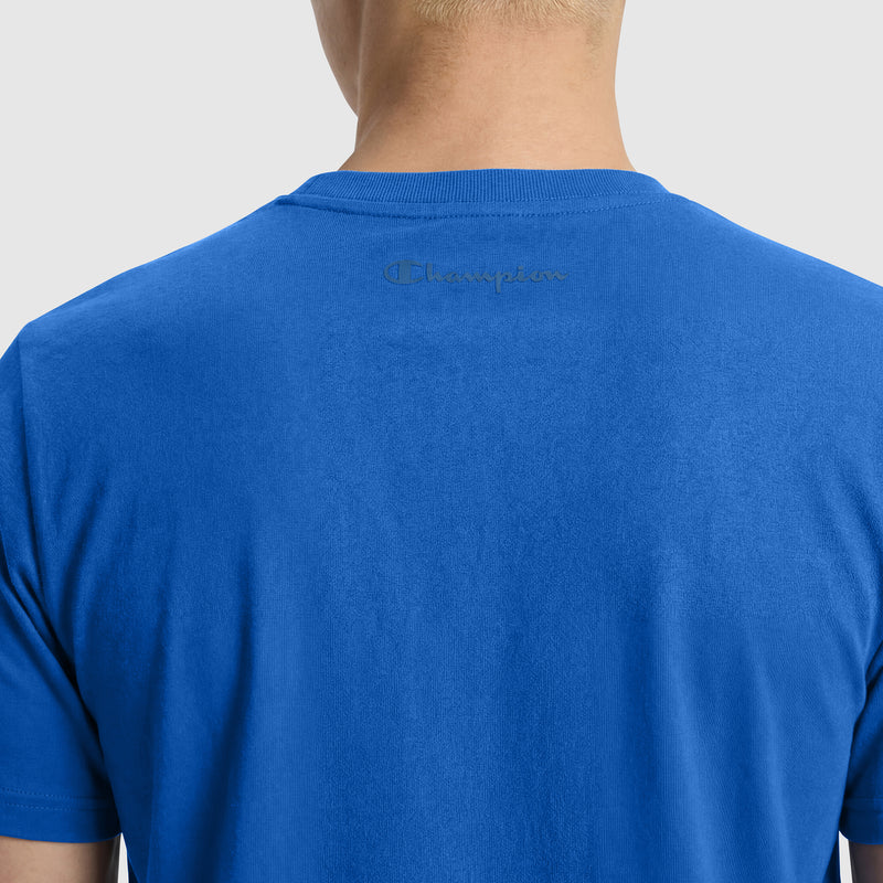 The image displays the back view of a bright blue Classic T-Shirt, C Logo by Champion. The cotton tee features an embroidered Champion logo near the upper back collar, set against a plain light gray background.