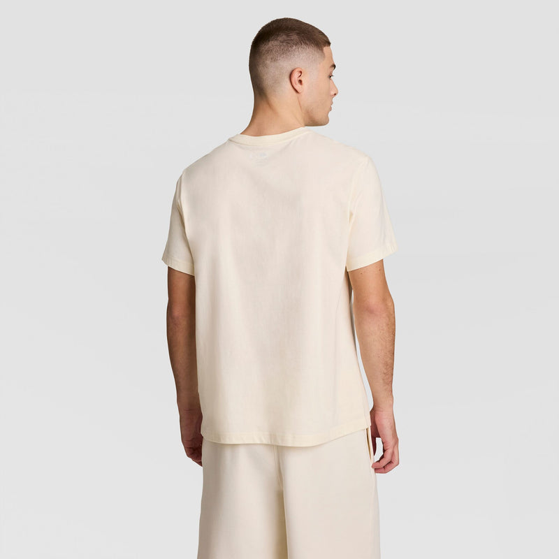 A person faces away from the camera, wearing a Champion Classic T-Shirt with C Logo and matching shorts, set against a plain, light gray background.